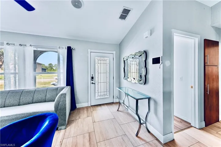 Foyer featuring vaulted ceiling and wood finish floors
