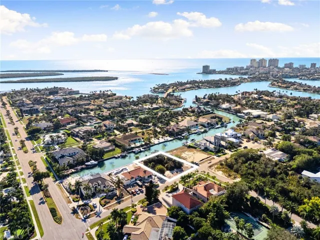 Aerial view of property and surrounding area featuring nearby suburban area and a nearby body of water