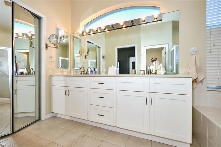 Full bathroom with double vanity and light tile patterned floors