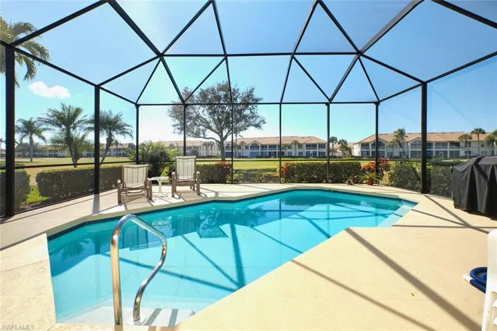 Outdoor pool with a sunroom, grilling area, a patio area, and a lanai