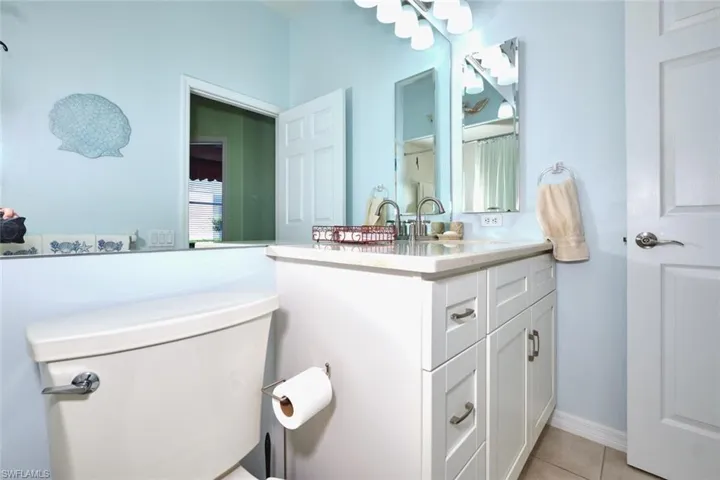 Half bath featuring vanity and light tile patterned floors