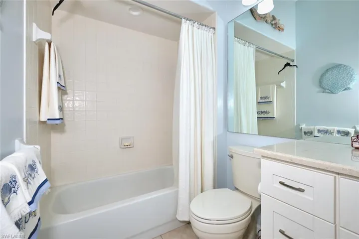 Bathroom with shower / bath combination with curtain and vanity