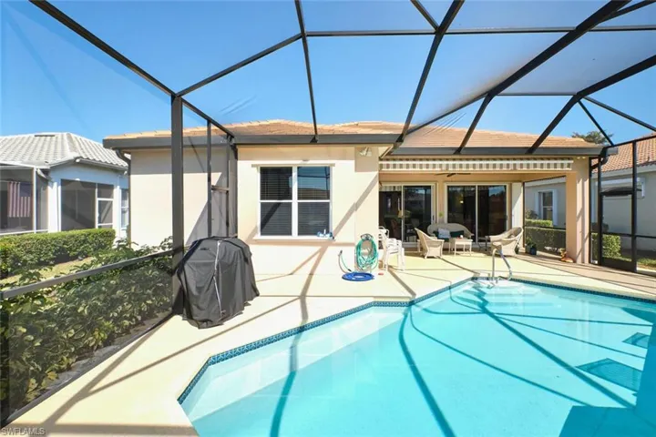 Outdoor pool with a lanai, a sunroom, a grill, and a patio area