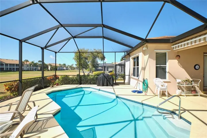 Outdoor pool with a sunroom, glass enclosure, a patio, and a grill