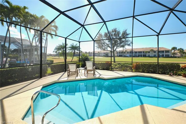 Swimming pool with a sunroom, glass enclosure, and a patio area