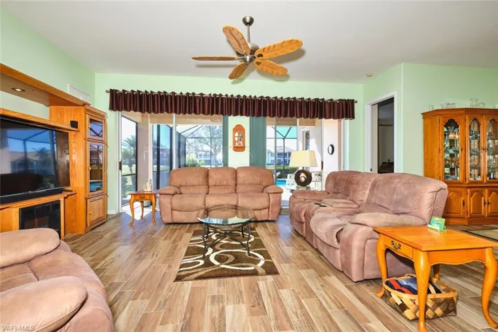 Living room with light wood finished floors and ceiling fan