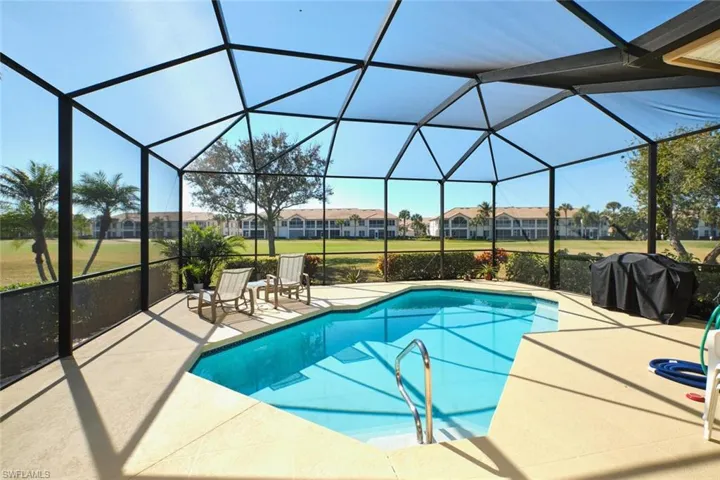 Outdoor pool with a sunroom, a grill, a yard, a residential view, and a patio