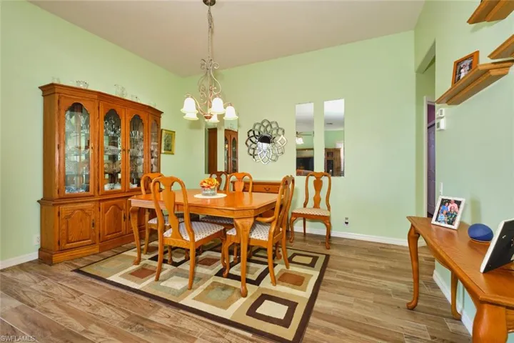 Dining space with light wood-style floors and suspended lighting