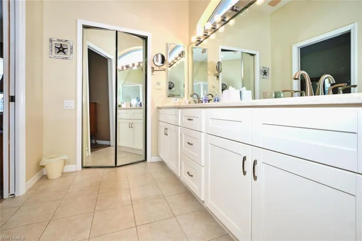 Full bath featuring double vanity and light tile patterned floors