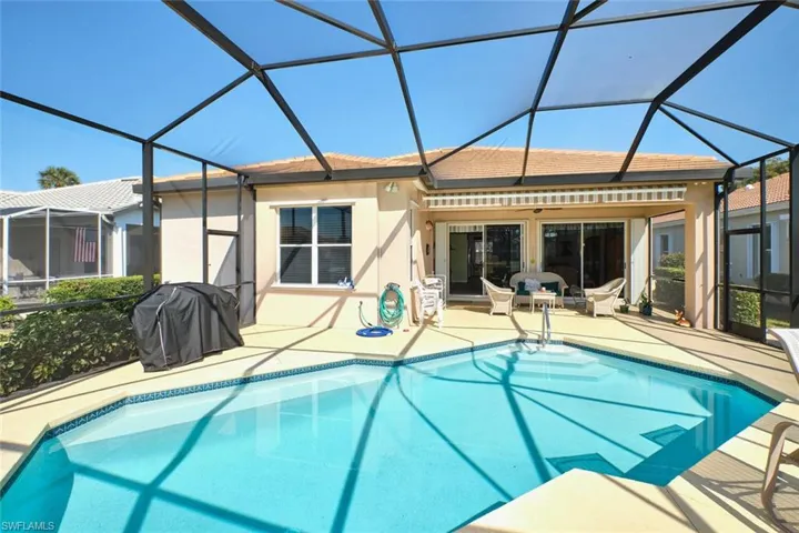 Swimming pool featuring a sunroom, a lanai, a grill, and a patio area
