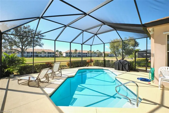 Swimming pool with a sunroom, a residential view, a patio, and grilling area