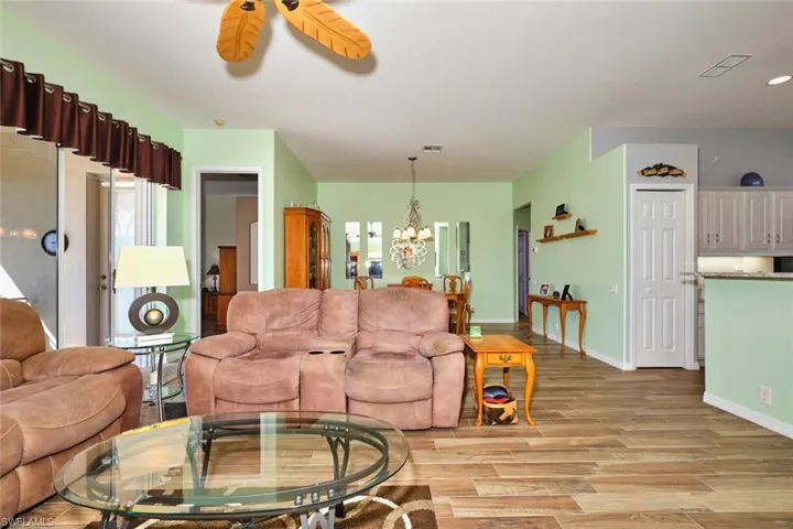 Living room with light wood-type flooring, a chandelier, and a ceiling fan