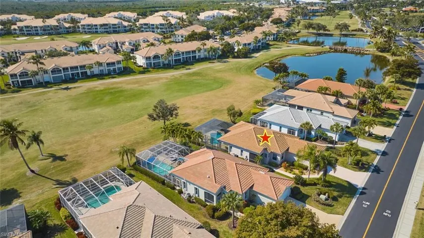 Aerial view of residential area featuring a large body of water and a golf club