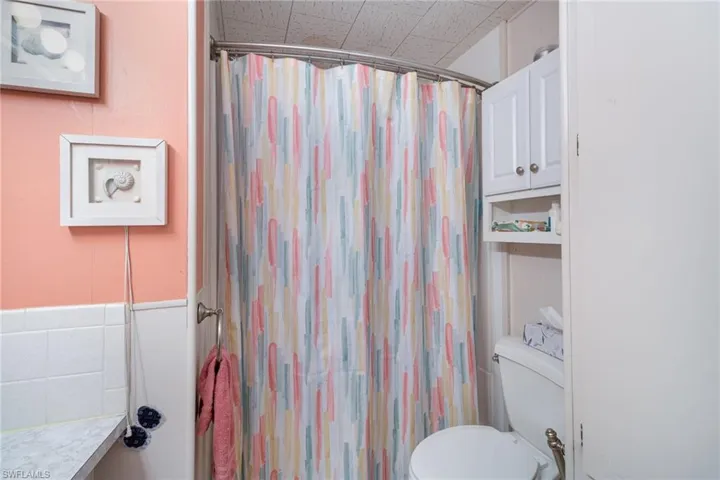 Bathroom with toilet and curtained shower