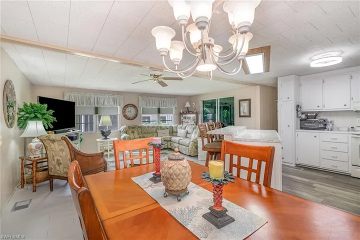 Dining space with a chandelier, light wood-style floors, and a ceiling fan