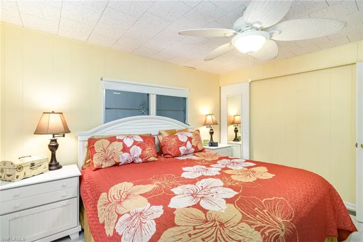 Bedroom with a ceiling fan and wood walls