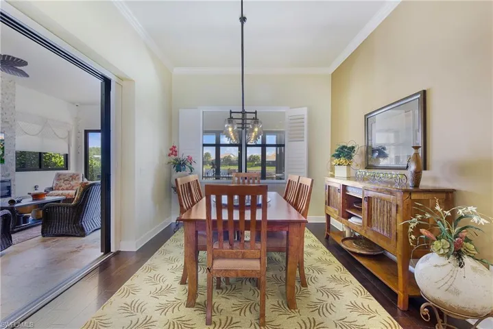 Dining room featuring ornamental molding, a chandelier, and dark wood finished floors