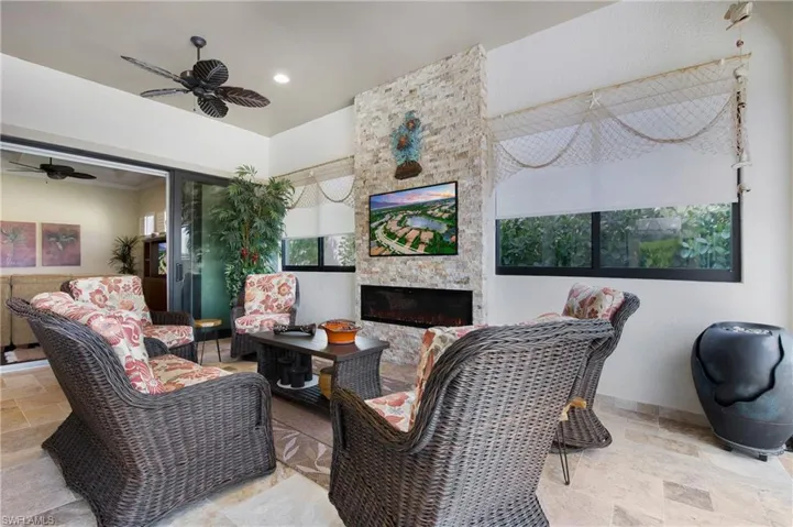 Sun room featuring stone tile floors, a ceiling fan, healthy amount of natural light, and recessed lighting