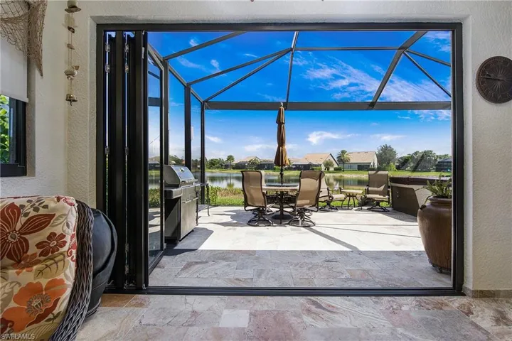 Sunroom featuring outdoor dining space and a water view