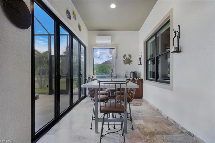 Sunroom featuring a wall mounted air conditioner and healthy amount of natural light
