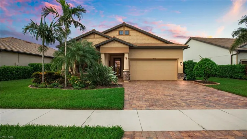 Craftsman-style house featuring decorative driveway, a garage, a yard, stone siding, and stucco siding