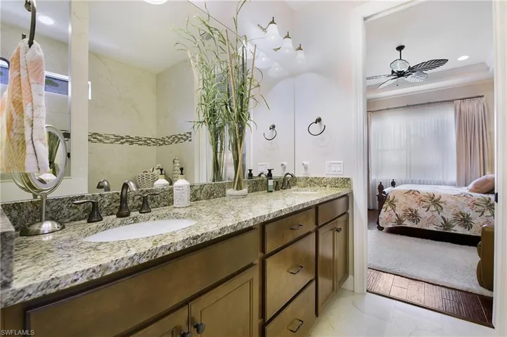 Bathroom featuring double vanity, connected bathroom, and ceiling fan