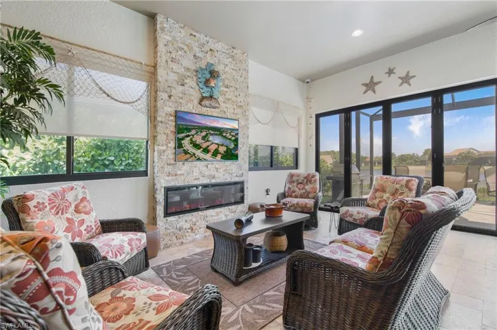 Sun room with a large fireplace, recessed lighting, and a textured wall