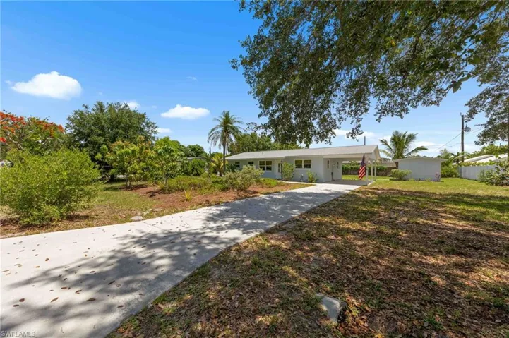 Ranch-style house featuring concrete driveway and an attached carport