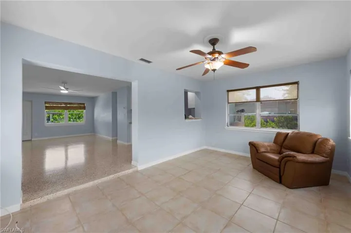 Living area with a ceiling fan and baseboards