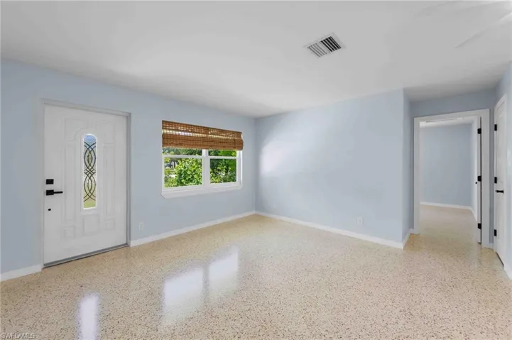 Entrance foyer with baseboards and speckled floor