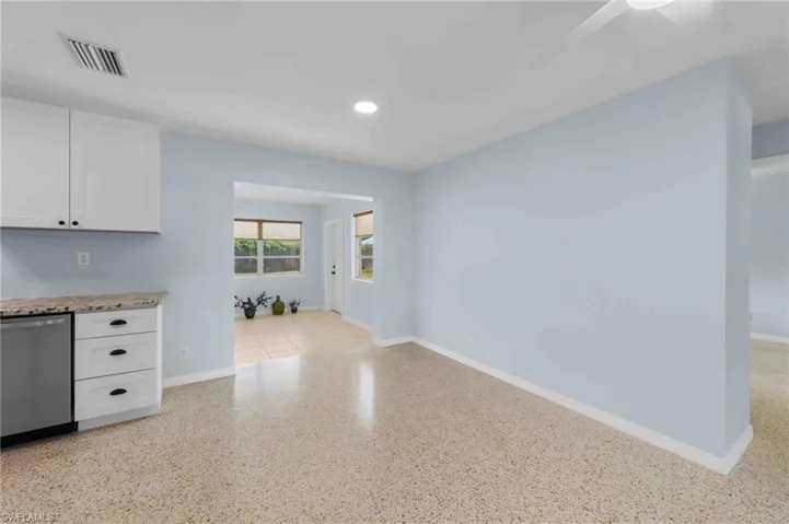 Unfurnished living room with baseboards, dark speckled floor, and recessed lighting