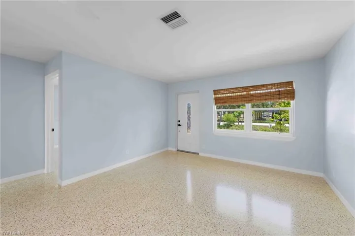Empty room with speckled floor and baseboards