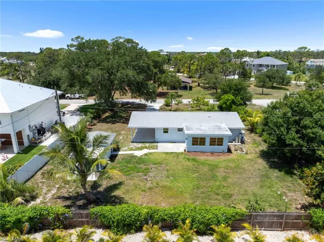 View of subject property featuring a tree filled landscape