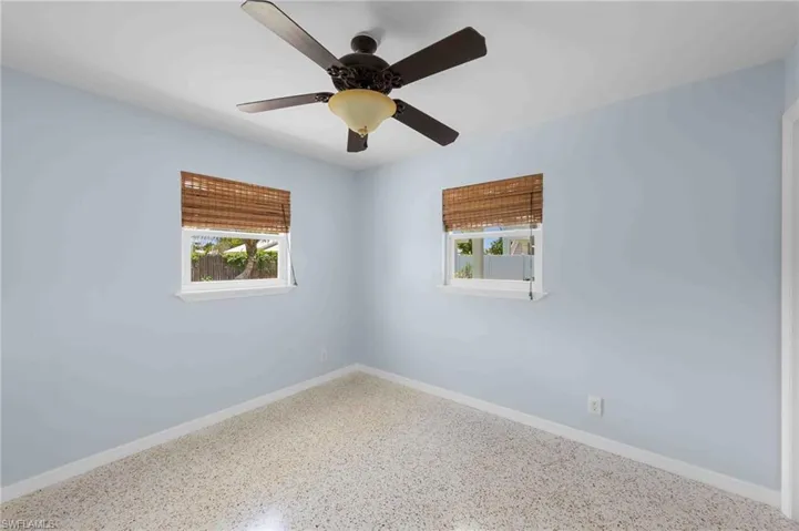 Spare room featuring speckle patterned floor and baseboards
