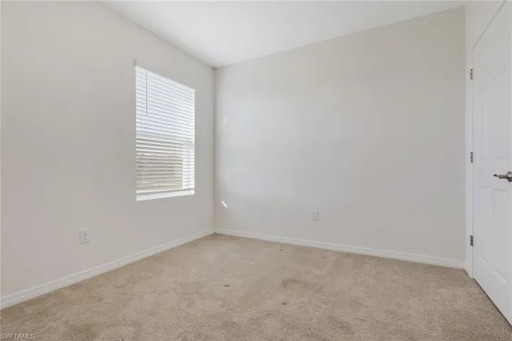Spare room with light carpet and baseboards