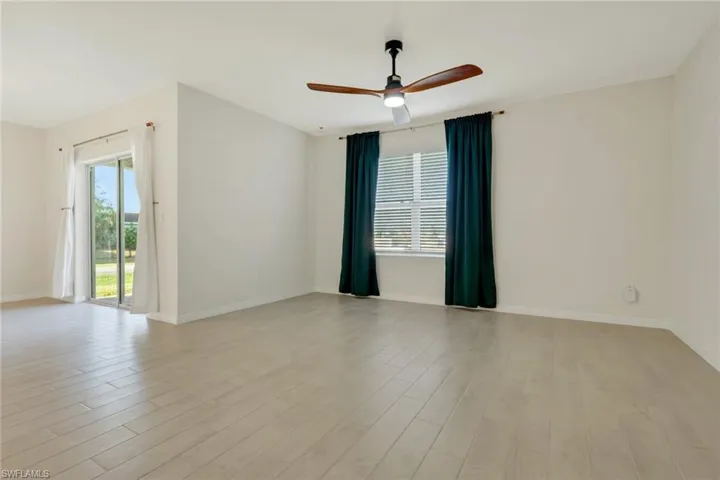 Spare room with ceiling fan, healthy amount of natural light, and light wood-style flooring