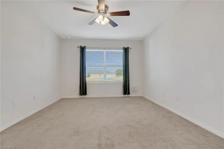 Unfurnished room with ceiling fan and light colored carpet
