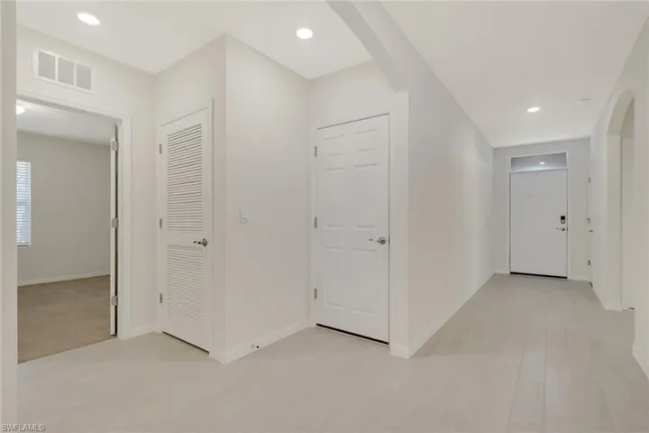 Hallway with arched walkways and recessed lighting