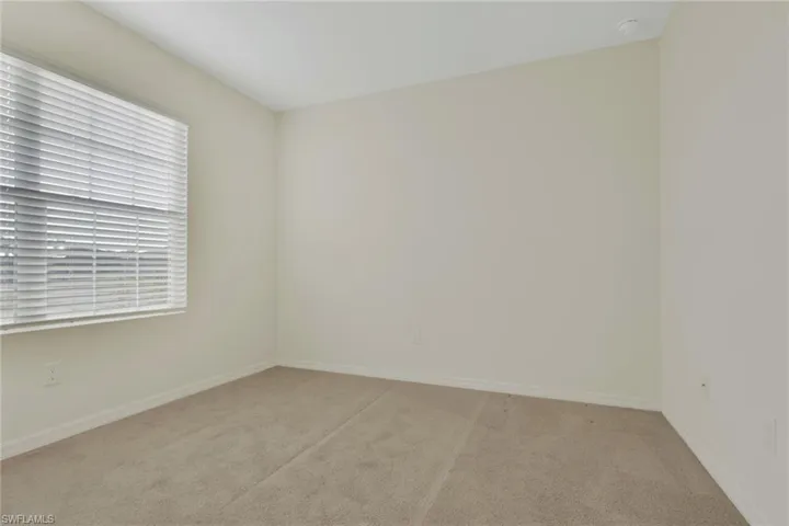 Carpeted empty room featuring baseboards