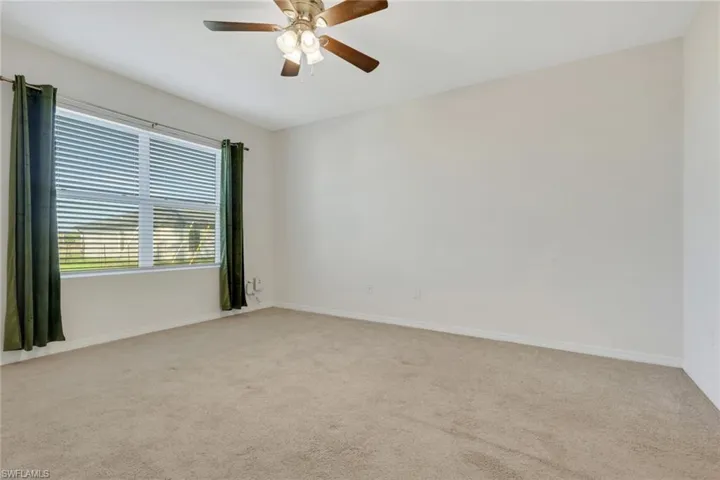Unfurnished room with light carpet and a ceiling fan