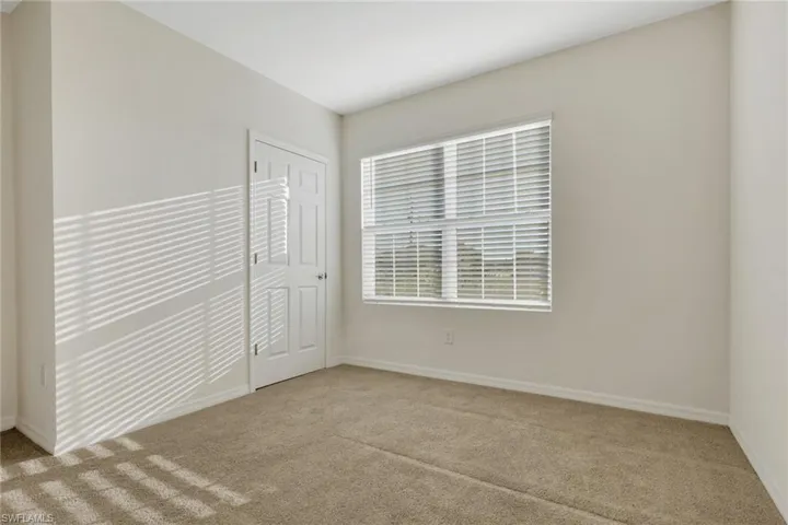 Unfurnished bedroom with light carpet and a closet
