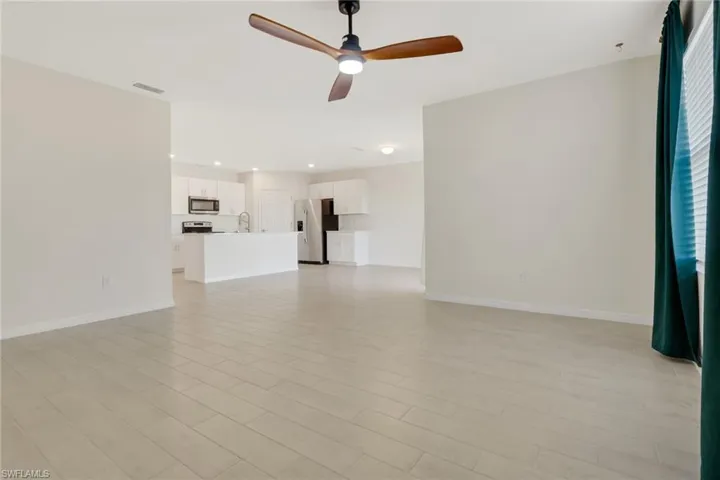 Unfurnished living room featuring ceiling fan and recessed lighting