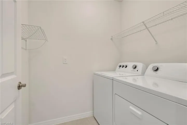 Washroom with baseboards and washing machine and clothes dryer