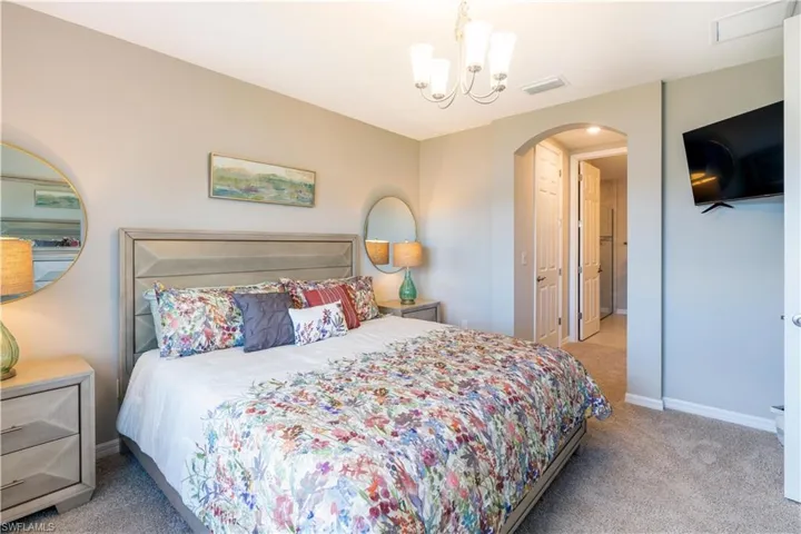 Bedroom featuring an inviting chandelier and light colored carpet