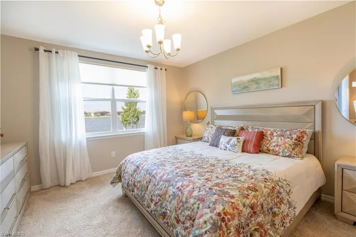 Carpeted bedroom with a notable chandelier