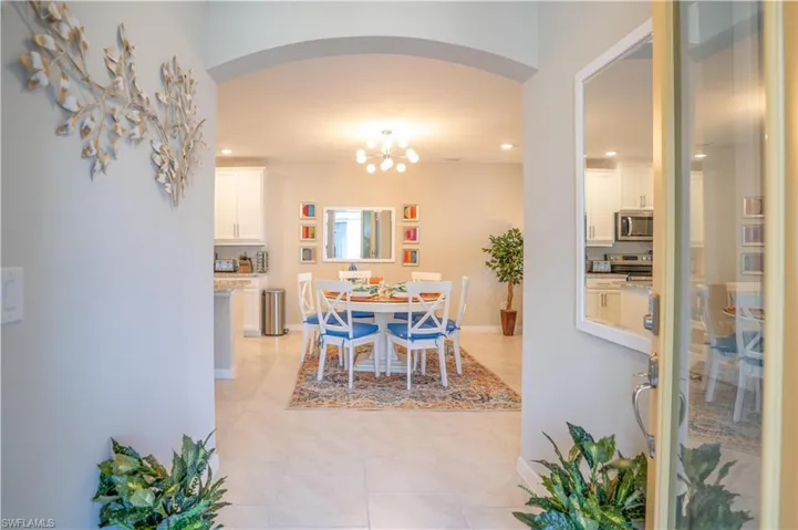 Dining room with light tile patterned flooring and a chandelier
