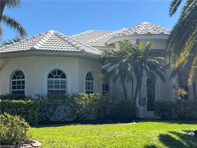 New exterior paint 3/2025 View of side of property featuring stucco siding, a lawn, and a tiled roof