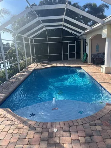 View of swimming pool featuring a lanai and a patio area