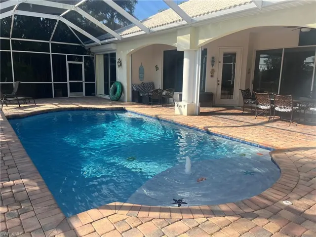 View of pool with a patio and glass enclosure