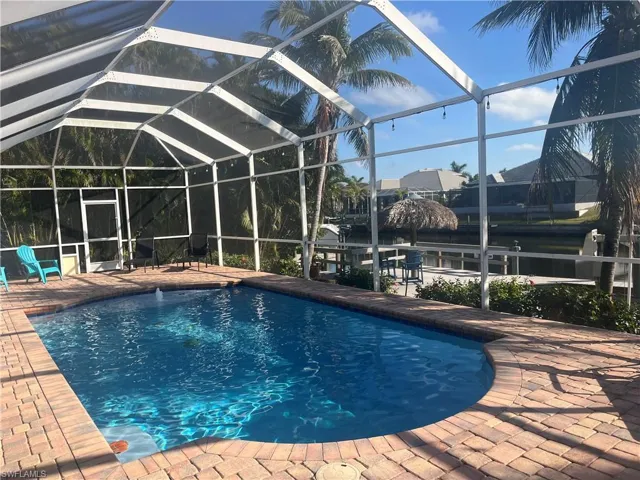 View of swimming pool with a patio and glass enclosure